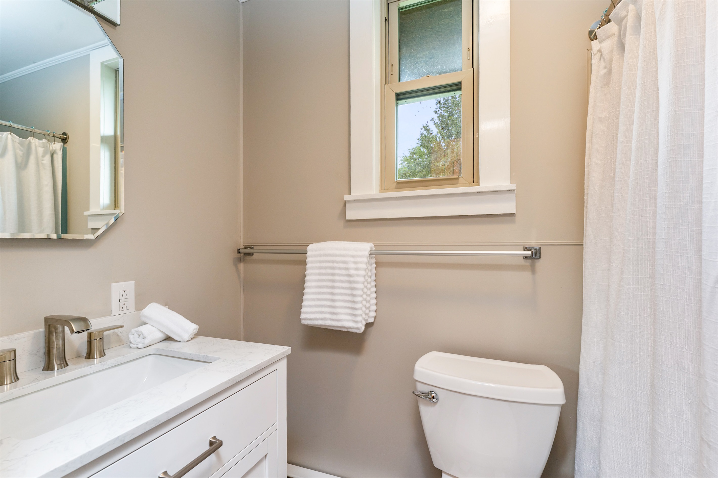 Fresh and modern bathroom featuring a sleek vanity, updated fixtures, and a clean design perfect for relaxation.