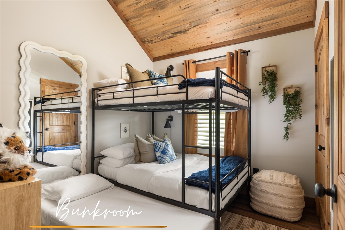 A full-over-full bunk bed with a twin pull-out creates a space designed for laughter, whispered stories, and the joy of being together!