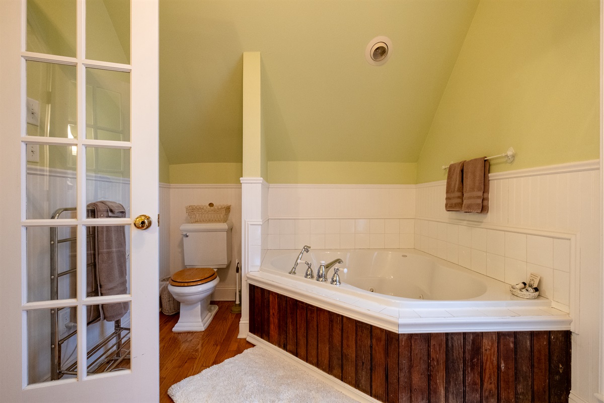 Spa bathroom with jetted soaking tub, classic tilework, and wainscoting details.