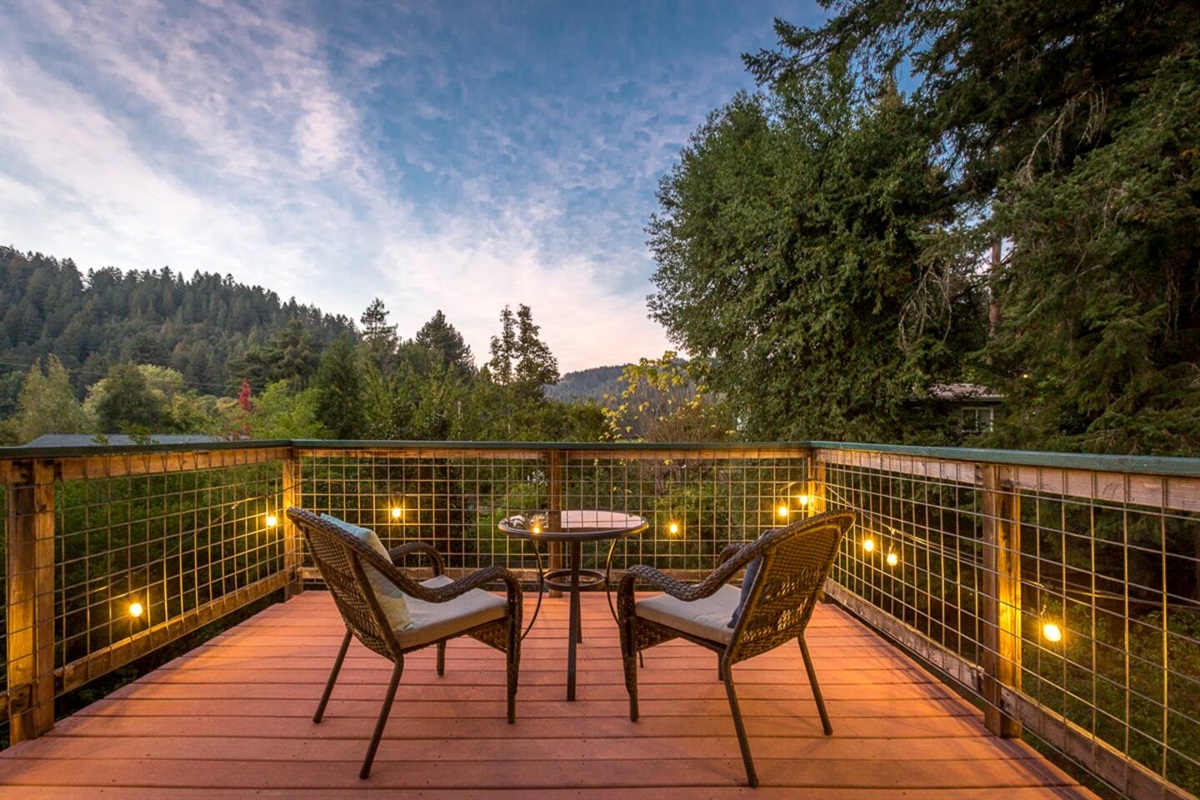 - Upper deck with bistro table and two chairs offering stunning forest views  
- Warm string lights create a magical setting for evening drinks or dining  
- Perfect for morning coffee while taking in the peaceful natural scenery  
