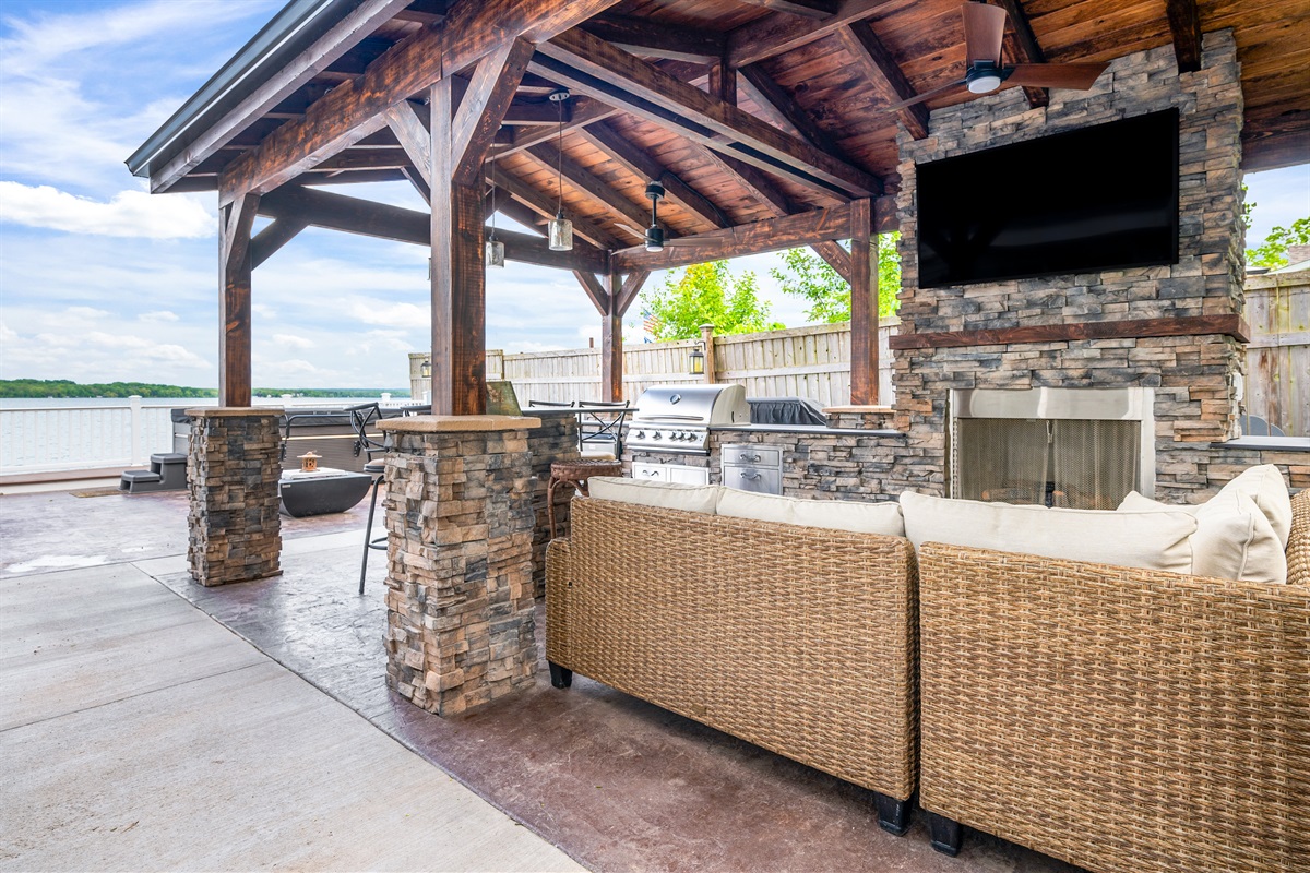 Gather under the stylish pavilion featuring a stone fireplace, TV, and grill for the ultimate outdoor hangout 🍔🔥📺