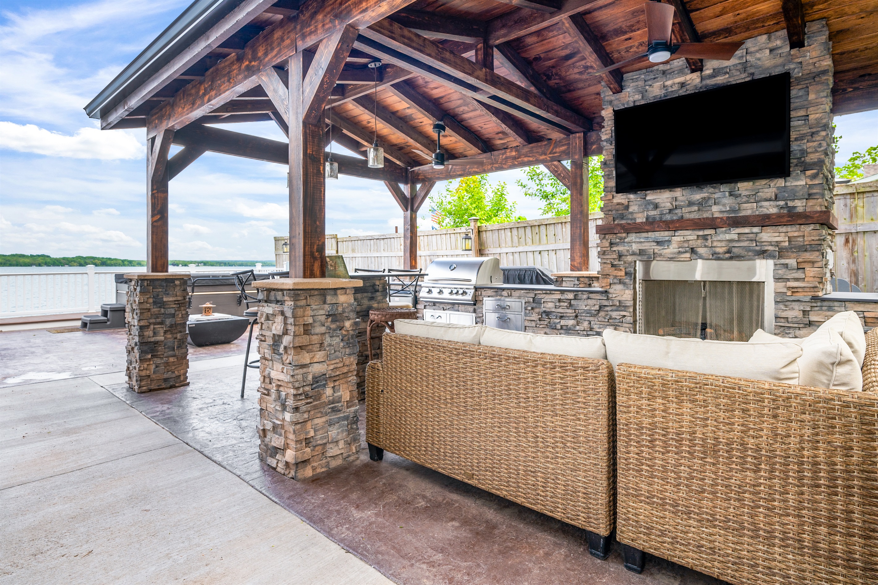 Gather under the stylish pavilion featuring a stone fireplace, TV, and grill for the ultimate outdoor hangout 🍔🔥📺