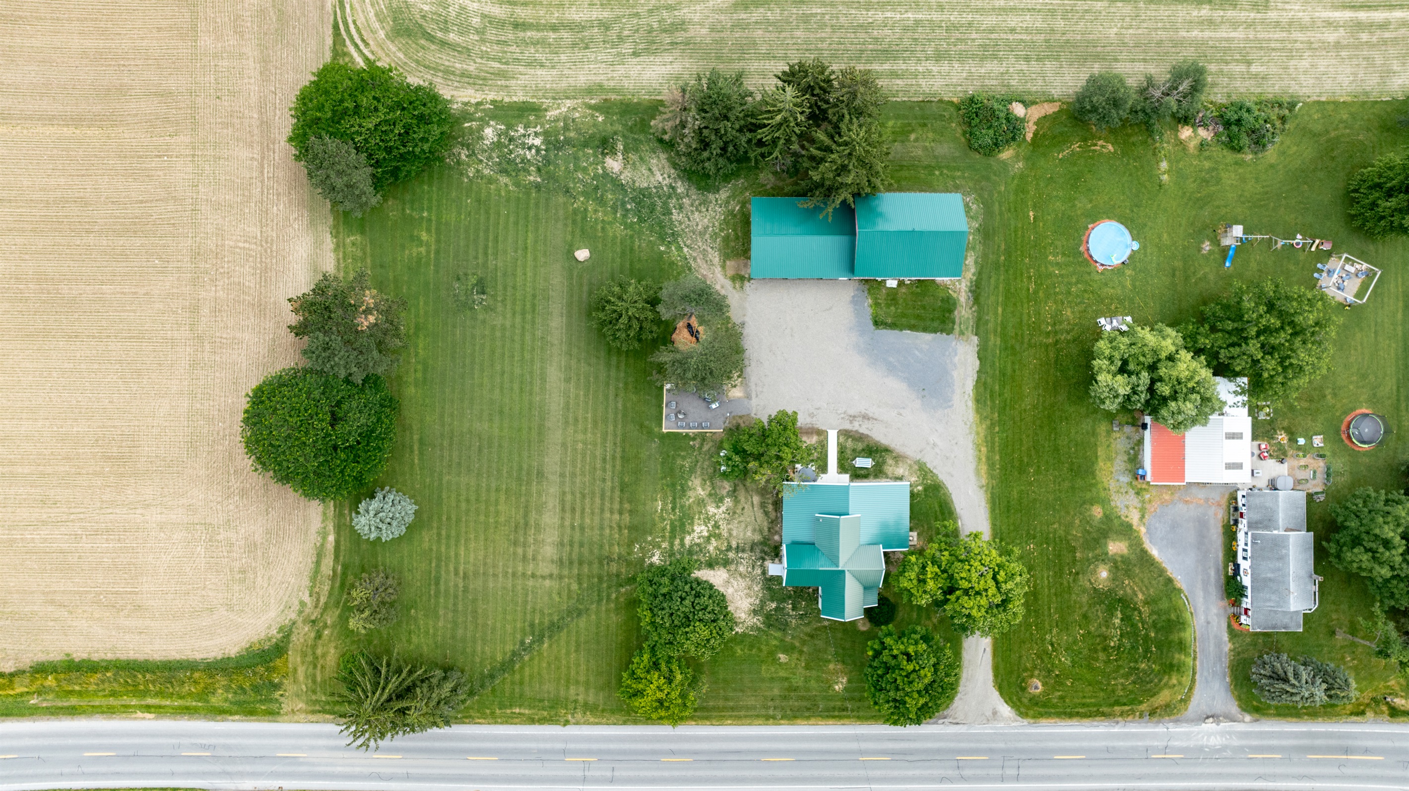 Bird’s-eye view of a well-maintained rural retreat with a long driveway, expansive lawn, and plenty of privacy from neighboring homes.