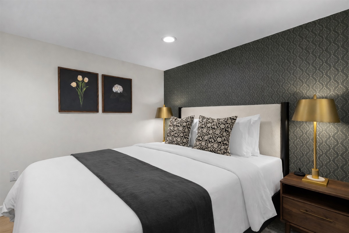 Serene bedroom retreat with a plush bed, crisp linens, soft lighting, and stylish accents—designed for restful nights and a truly comfortable stay.