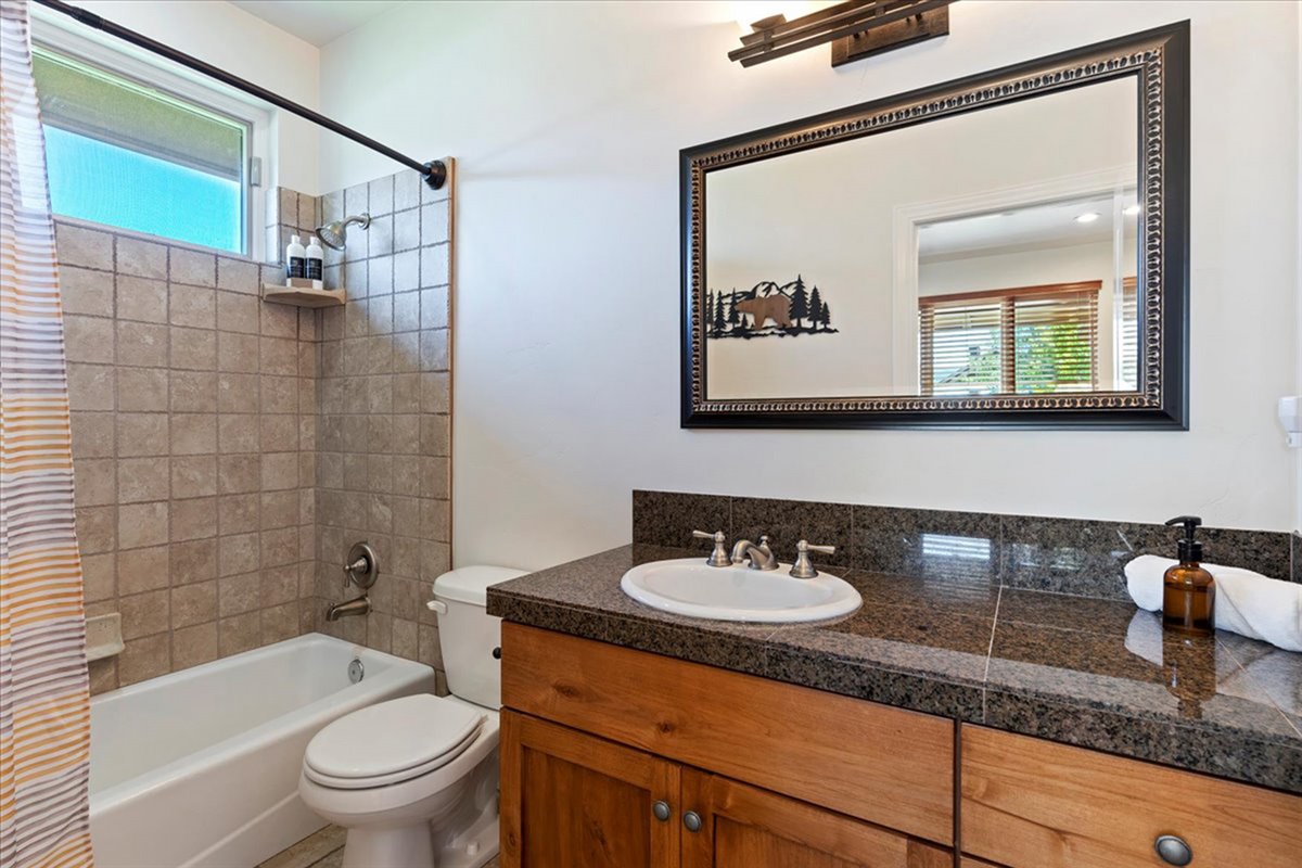 The ensuite bathroom for the king bedroom, complete with a tub/shower combo and ample counter space for your stay.