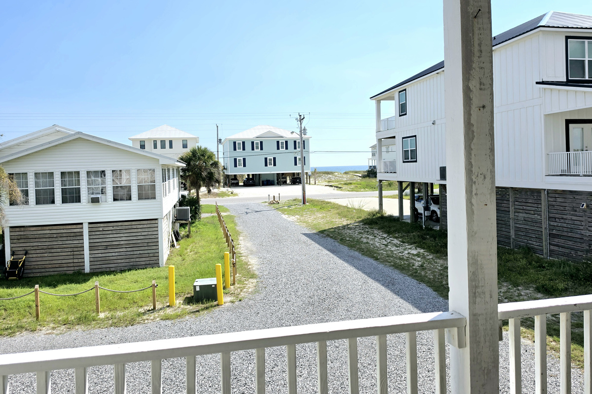 Nest side – Covered balcony view down the street toward the Gulf