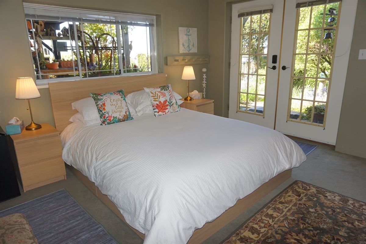 Garden Room- downstairs second bedroom (queen bed).    This charming bedroom has French doors which lead out to the garden and enjoys a lower view of the harbour and the charismatic potting area.   It has an adjoining bathroom.