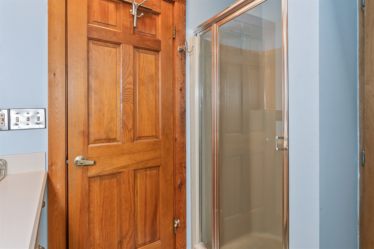 Spacious walk-in shower with warm wood accents for a relaxing start to your day.