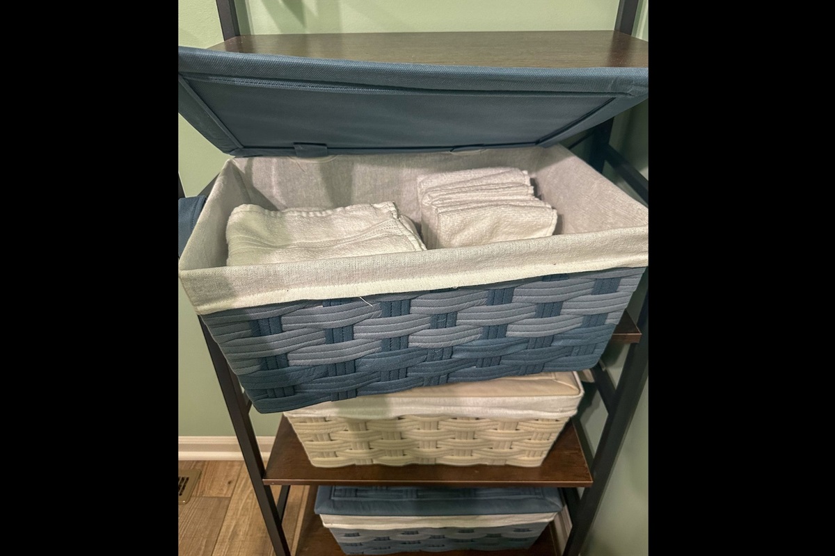 Half bath shelving with neatly folded hand towels and washcloths, keeping essentials within easy reach.