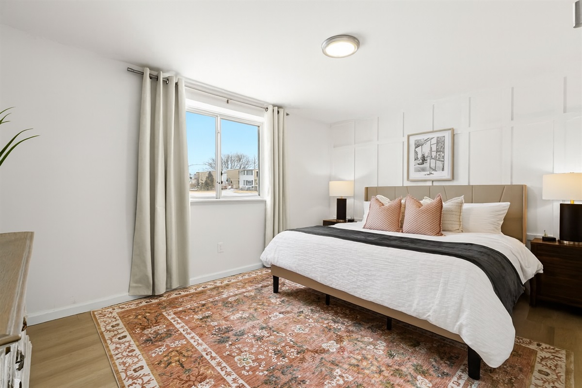 Sleep in style with a king-size bed, plush pillows, and elegant matching lamps.