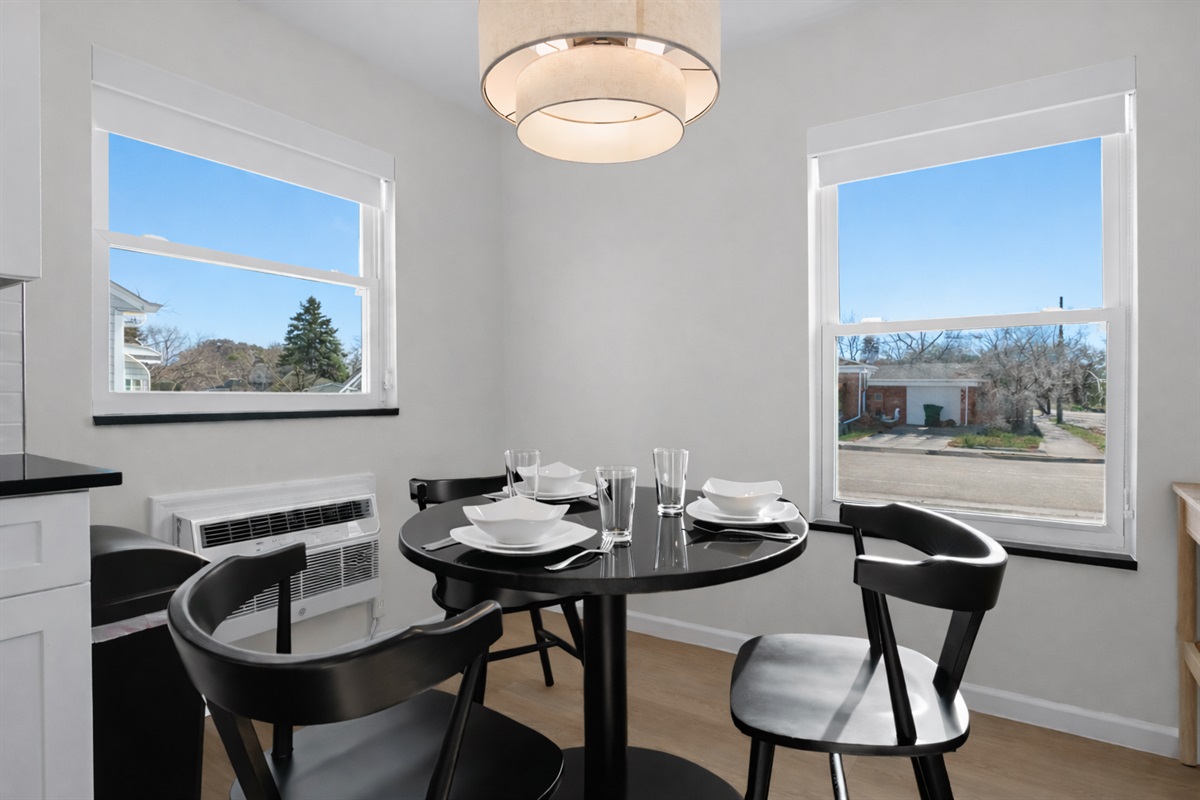 Sun-filled dining nook with modern table setting, stylish chairs, and soft pendant lighting—an inviting spot for meals, coffee, or conversation.
