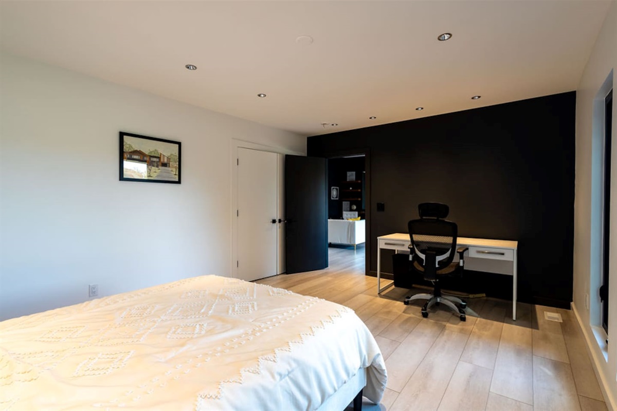 Comfortable bedroom with a dedicated work space, featuring a desk and chair, perfect for those who need to blend relaxation with productivity.