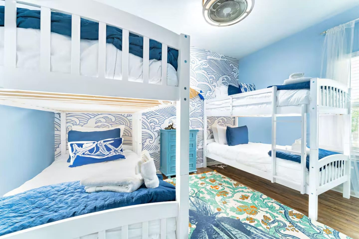 Cozy twin bunk beds provide a comfortable and playful space where kids and friends can relax after a day at the beach