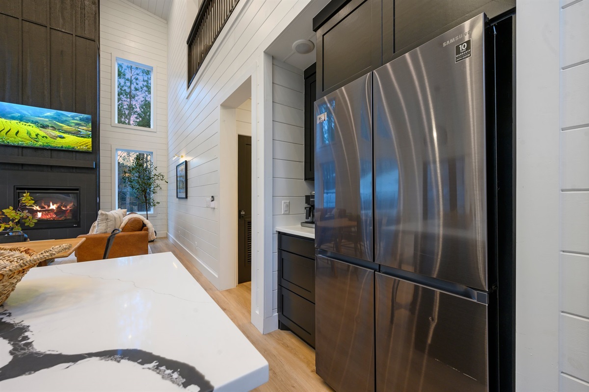 The full-size stainless steel refrigerator offers ample space for groceries and weekend getaway provisions, seamlessly blending into the kitchen’s modern design.