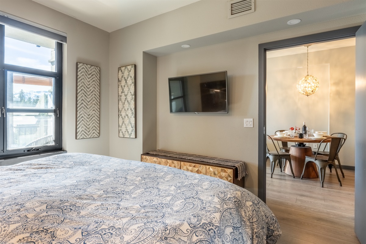 An open sightline from bedroom to living/dining keeps the space feeling airy and connected.