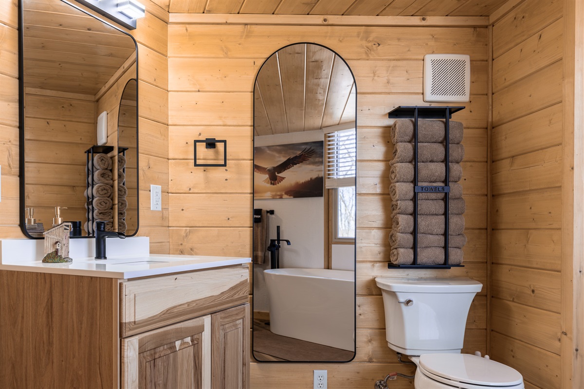 Modern vanity with mirror, plush towels, and spa-style finishes.