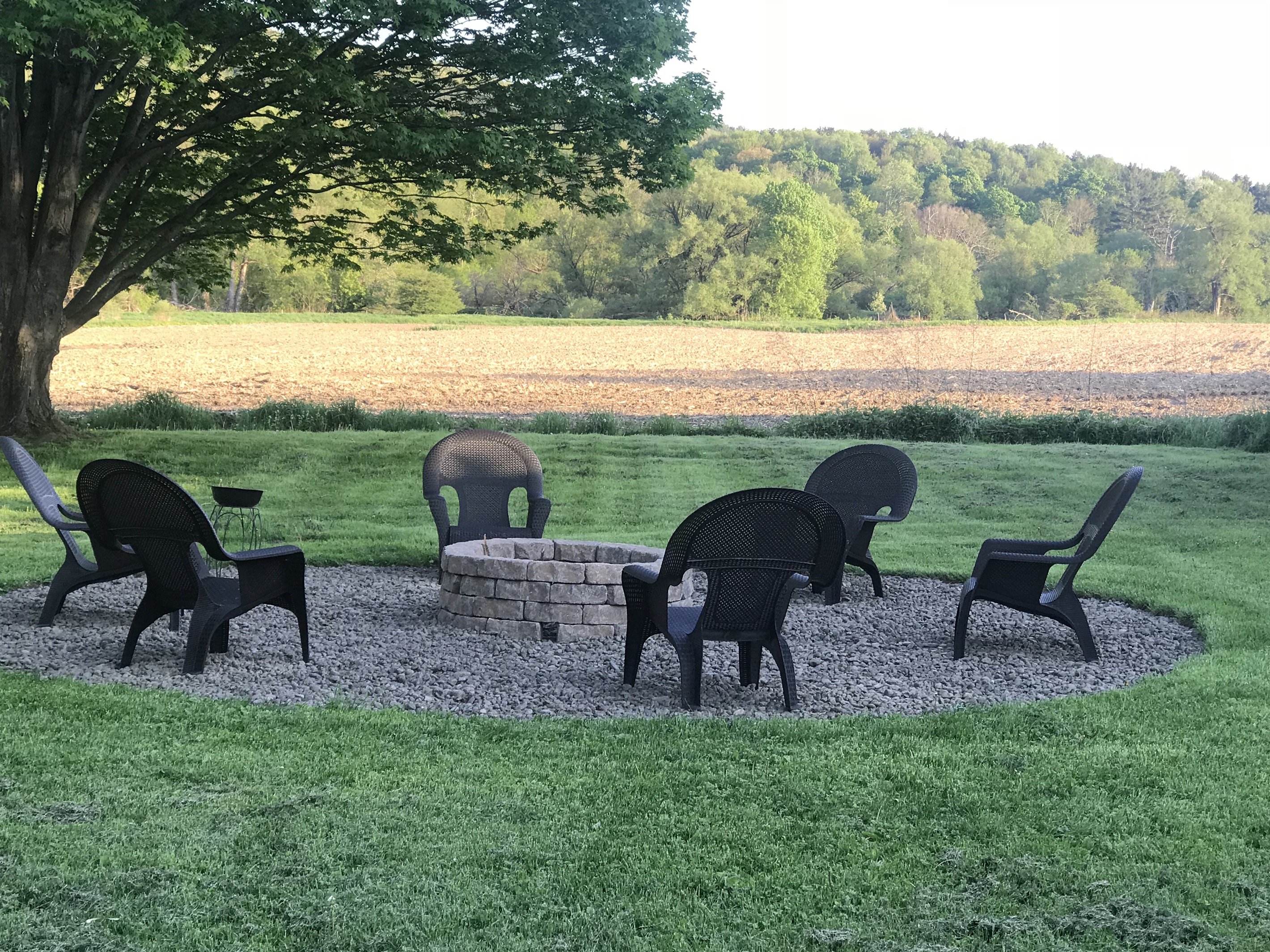Fire pit in yard overlooking expansive meadow and gentle hills