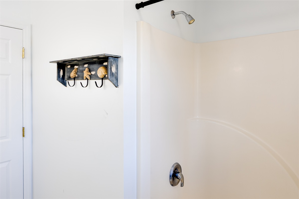 An easy-to-use walk-in shower with fresh towels and simple coastal touches in master bathroom