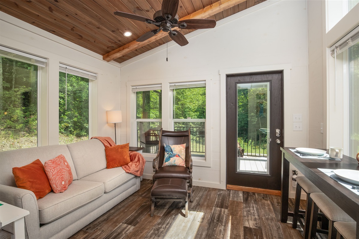 Floor-to-ceiling windows bring the outdoors in, filling the living space with natural light.