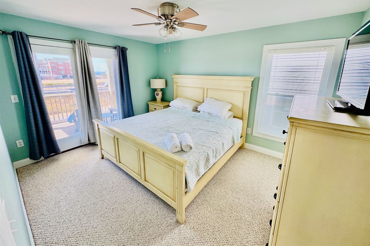 Bright King bedroom with Smart TV and direct deck access.