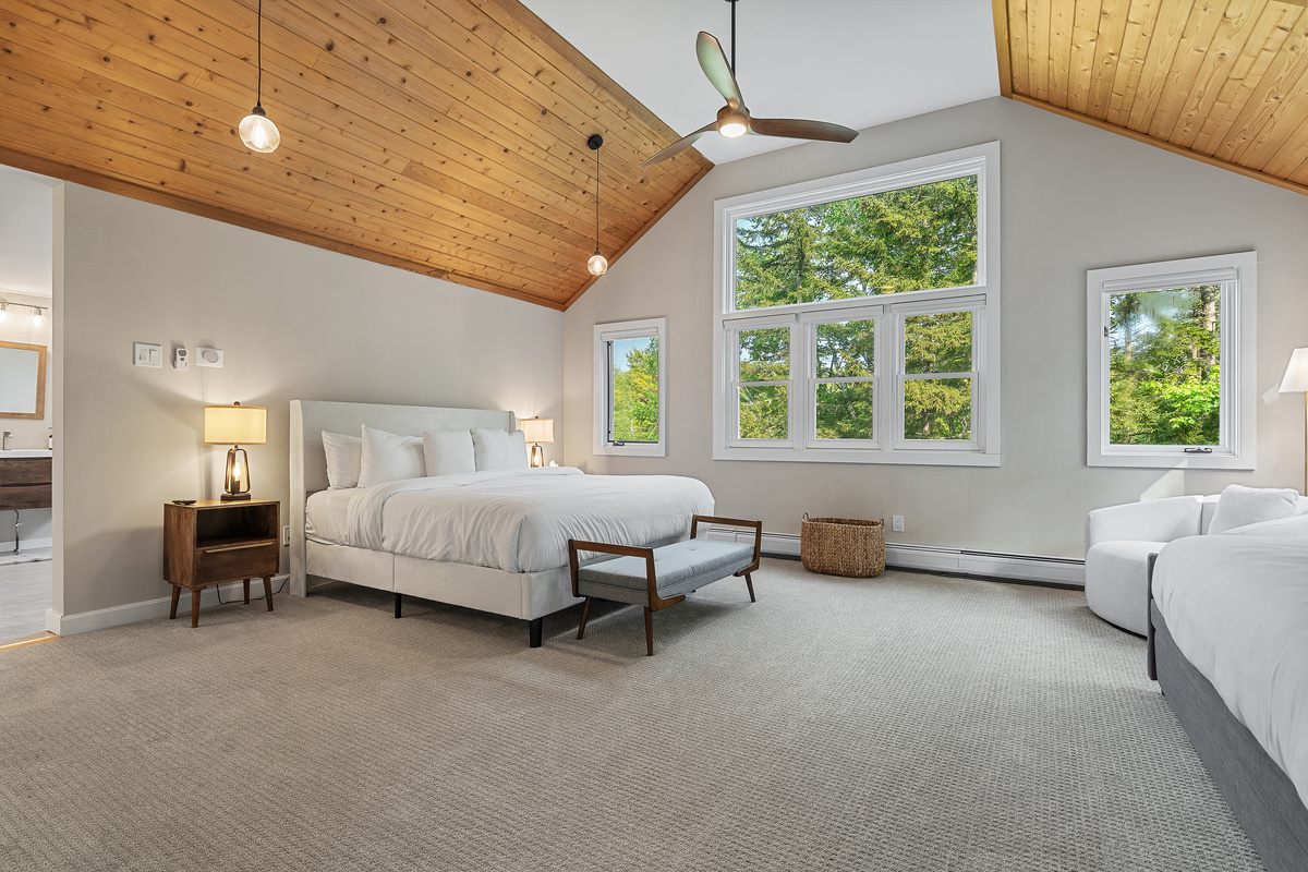 Primary bedroom with cathedral pine ceiling, king bed and extra daybed seating