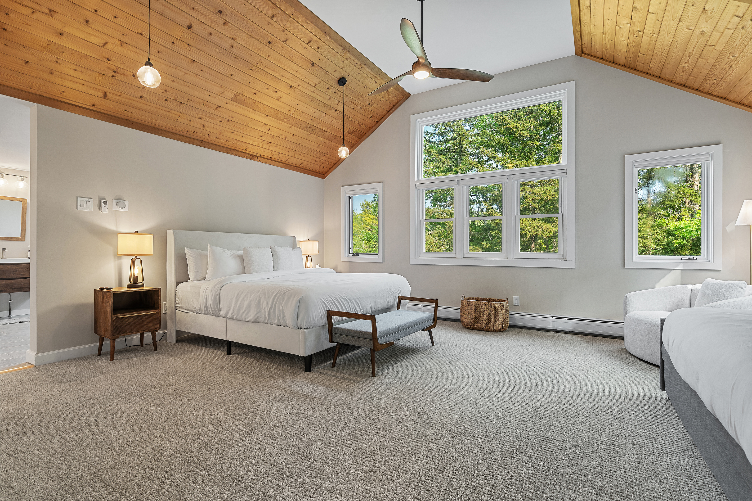 Primary bedroom with cathedral pine ceiling, king bed and extra daybed seating