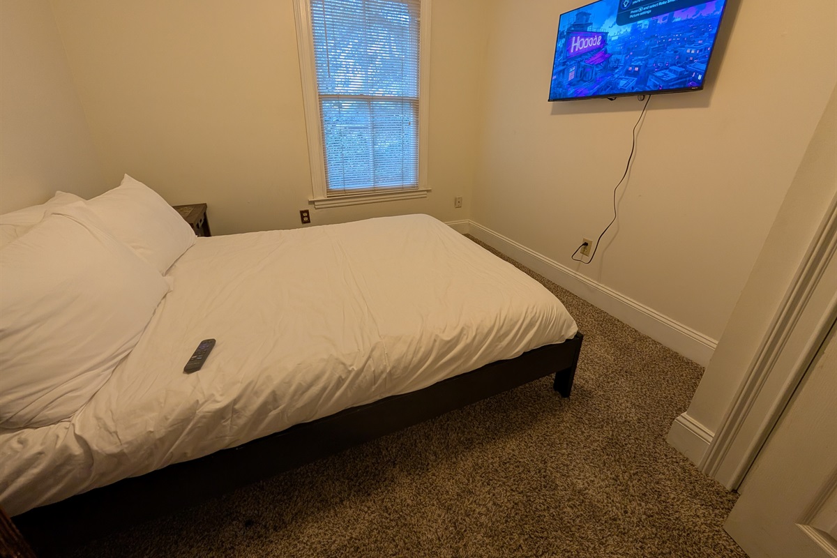 Guest bedroom upstairs with queen bed and smart tv