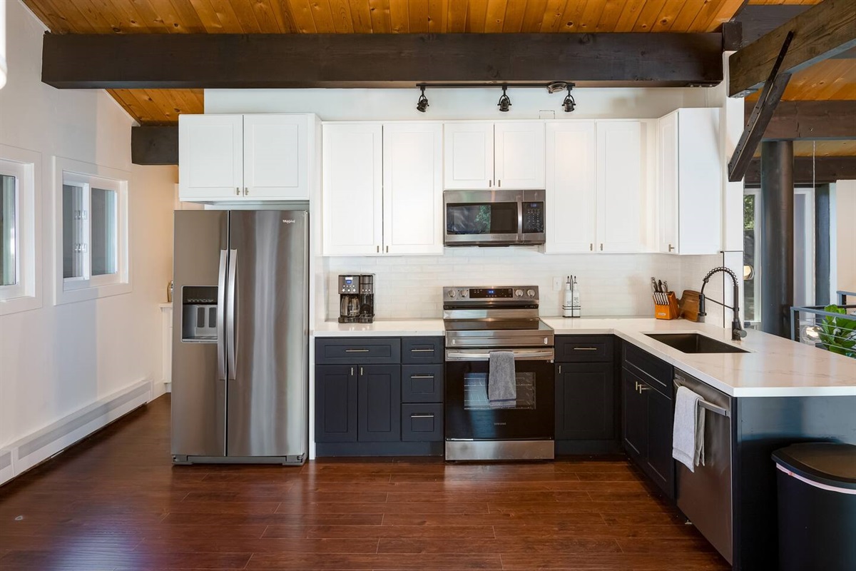 All new appliances:  refrigerator, Samsung oven, microwave, and dishwasher.This is a cleaner photo look, although the kitchen does come fully-stocked with cooking utensils, toaster, blender, strainer, cooking pans, mixing bowls, etc.
