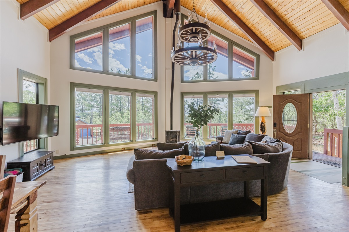 A bright and inviting living room with floor-to-ceiling windows that bring the outdoors in—perfect for morning coffee or cozy evenings by the fire.