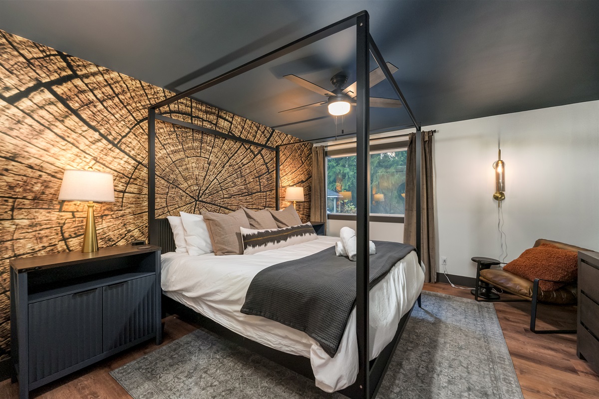 A stylish king bedroom with a bold timber accent wall and plush bedding creates the perfect retreat after a day on the mountain.