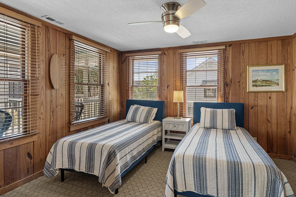 A comfortable upstairs bedroom with a ceiling fan and that easy coastal warmth. ⭐