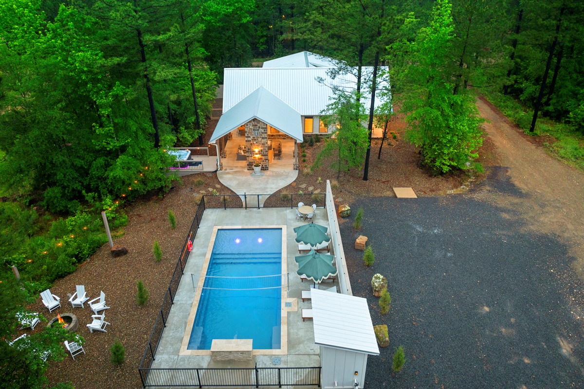 An aerial look at the heart of the property: the pool, covered patio, hot tub, & firepit create the perfect setting for a memorable stay with parking conveniently located to the right. Not pictured: Kids playset and fenced yard for dogs!