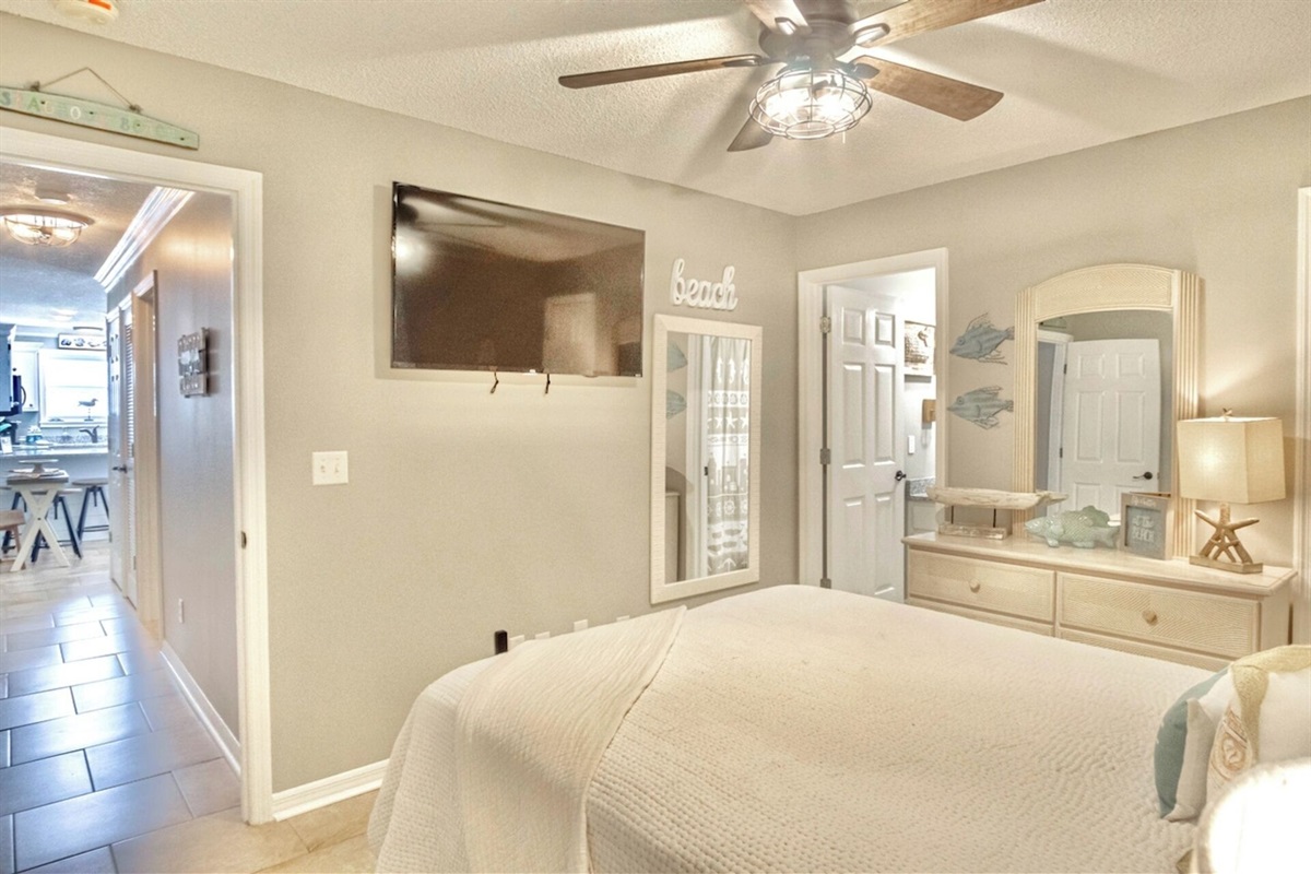 Master bedroom with queen bed, smart TV, ceiling fan, and ensuite bathroom