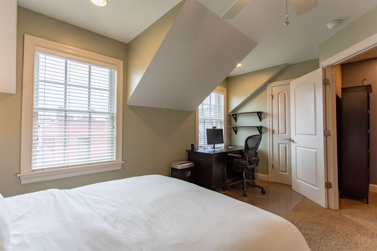 Bedroom with a dedicated workspace, featuring a comfortable desk and chair, perfect for productivity or quiet moments of focus.