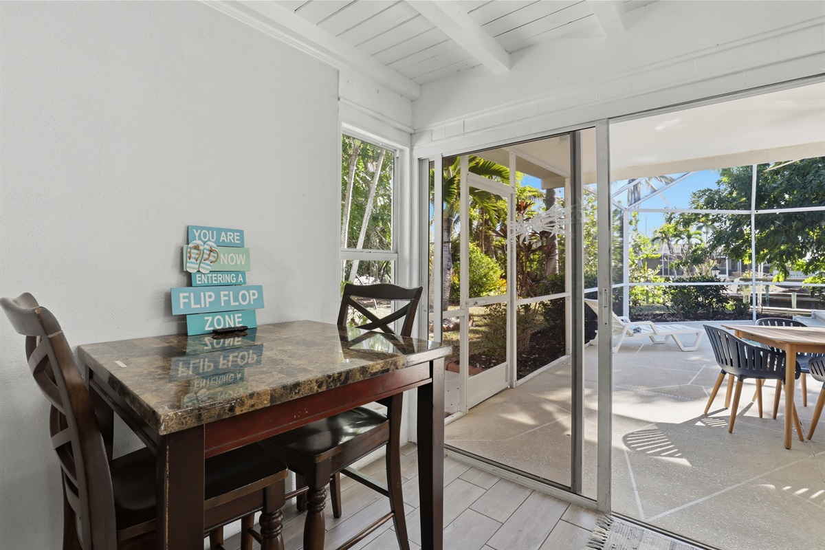 Game room with bar table, TV, couch and foosball table. 