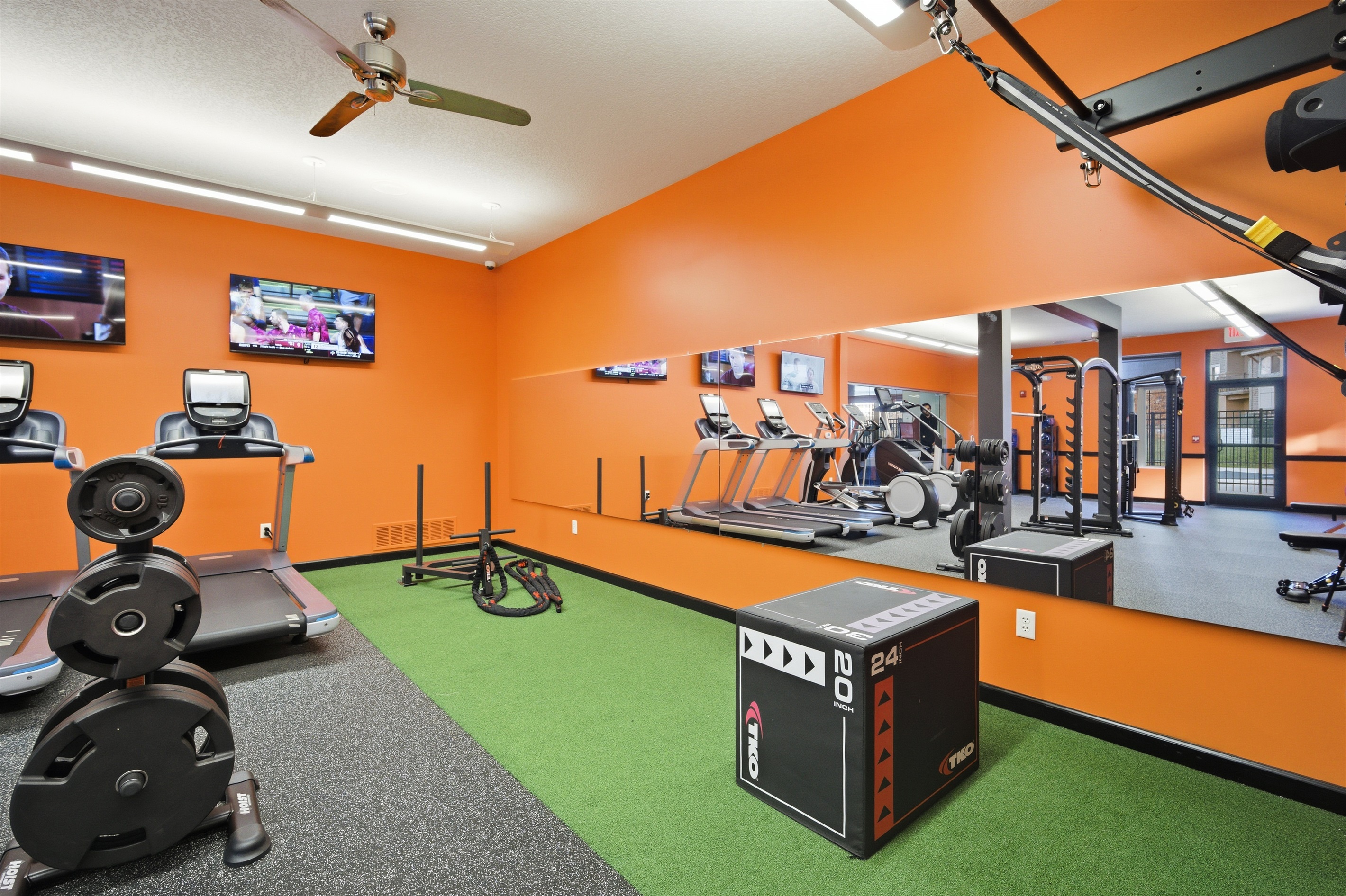 Large mirrored wall enhances visibility and form during workouts supporting everything from strength training to personal fitness routines in a clean, well-lit environment
