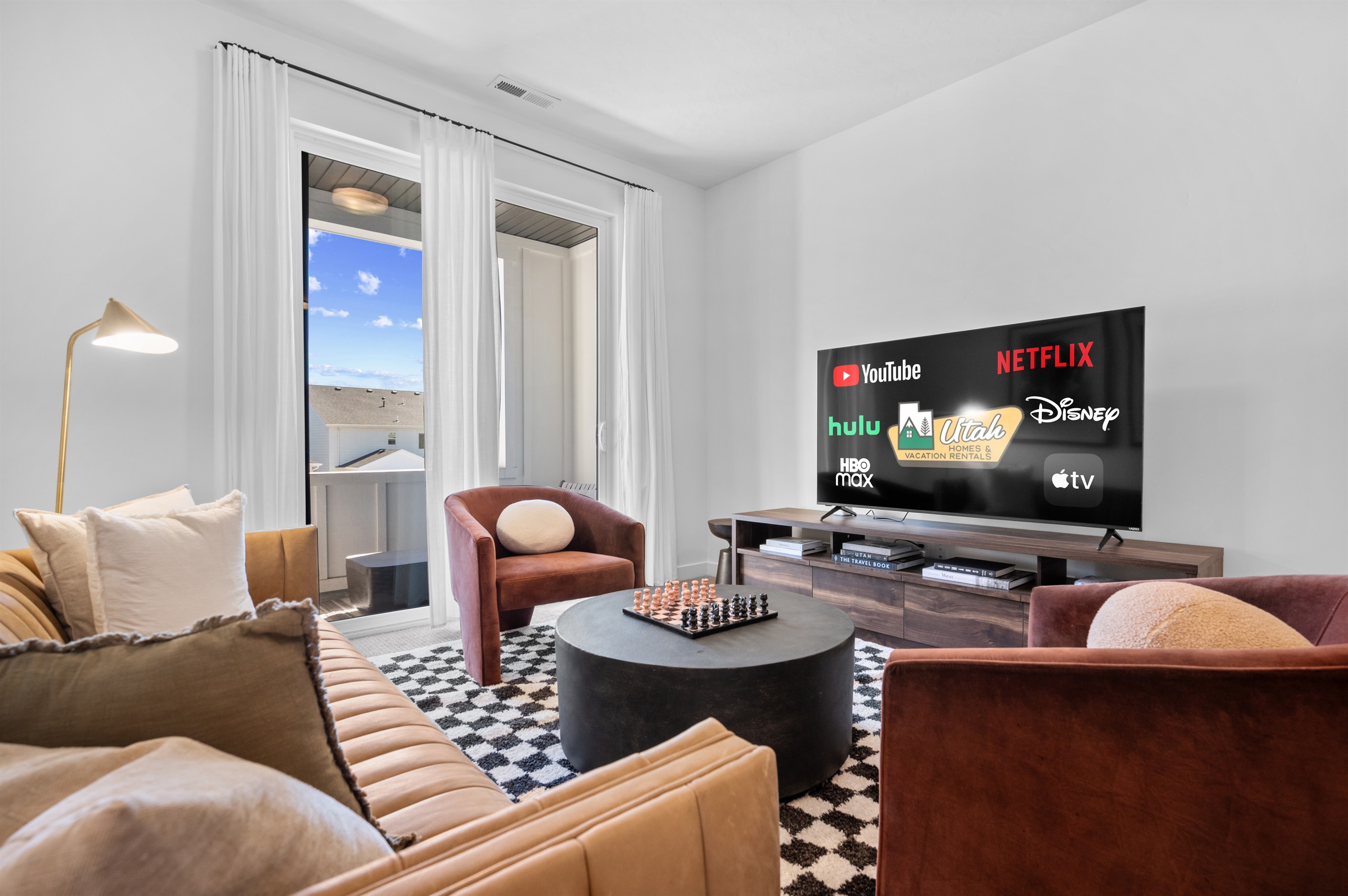 The versatile sitting room offers a chic space to relax, gather, or enjoy a game of chess.