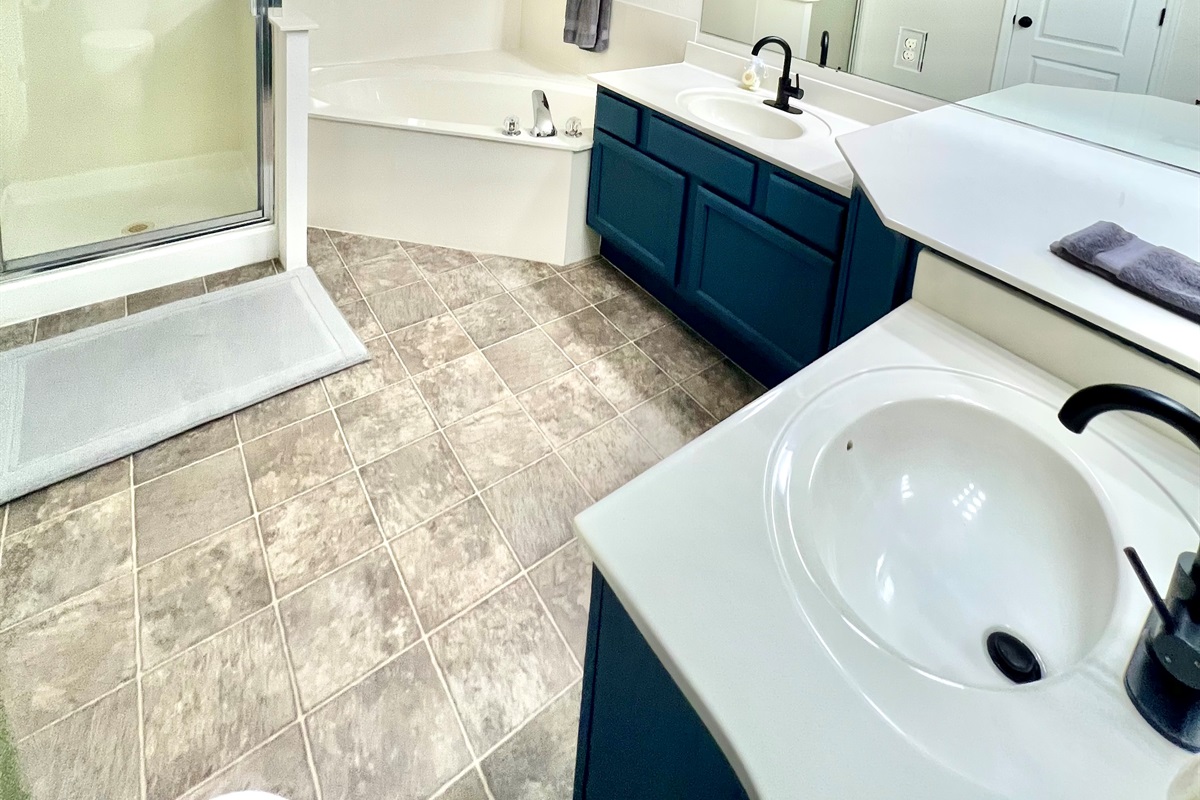 Indulge in a spa-like experience in the master bathroom, featuring a spacious walk-in shower and a luxurious soaking tub.