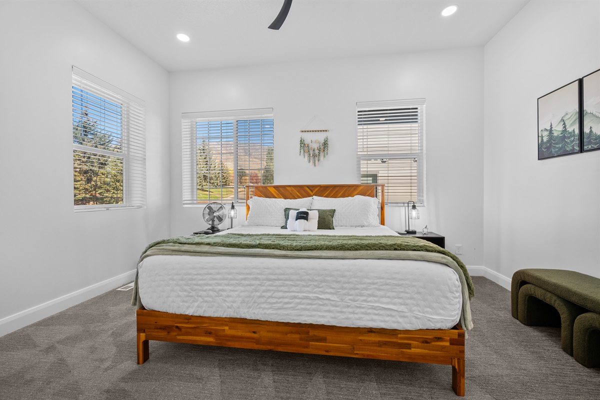 Primary bedroom featuring a king bed, ceiling fan, and stunning views