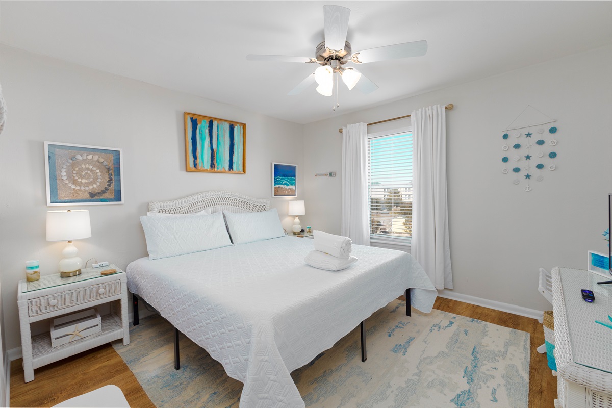 Coastal-inspired master bedroom with cozy linens and serene natural light