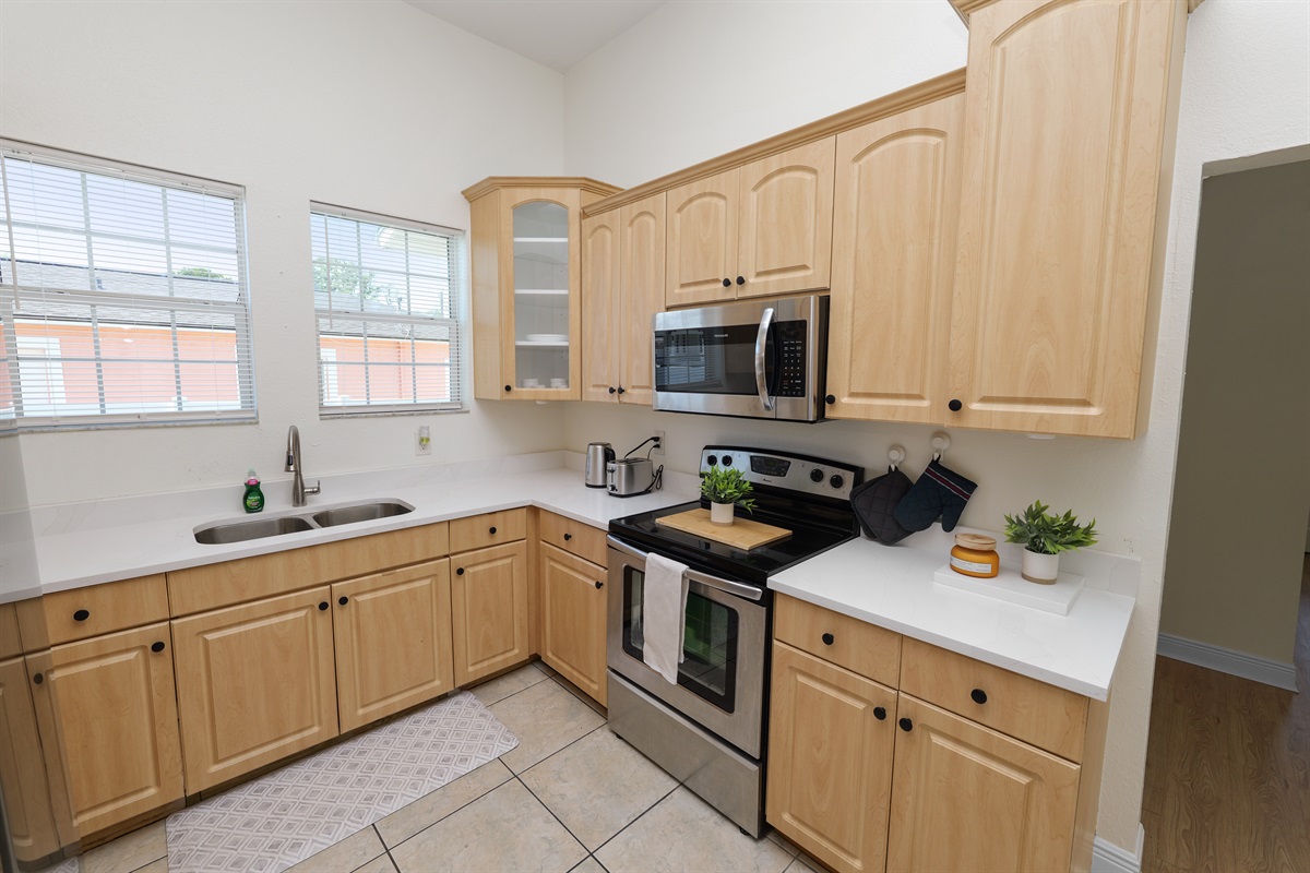 Natural wood cabinetry meets clean white countertops in this charming kitchen designed for both form and function.