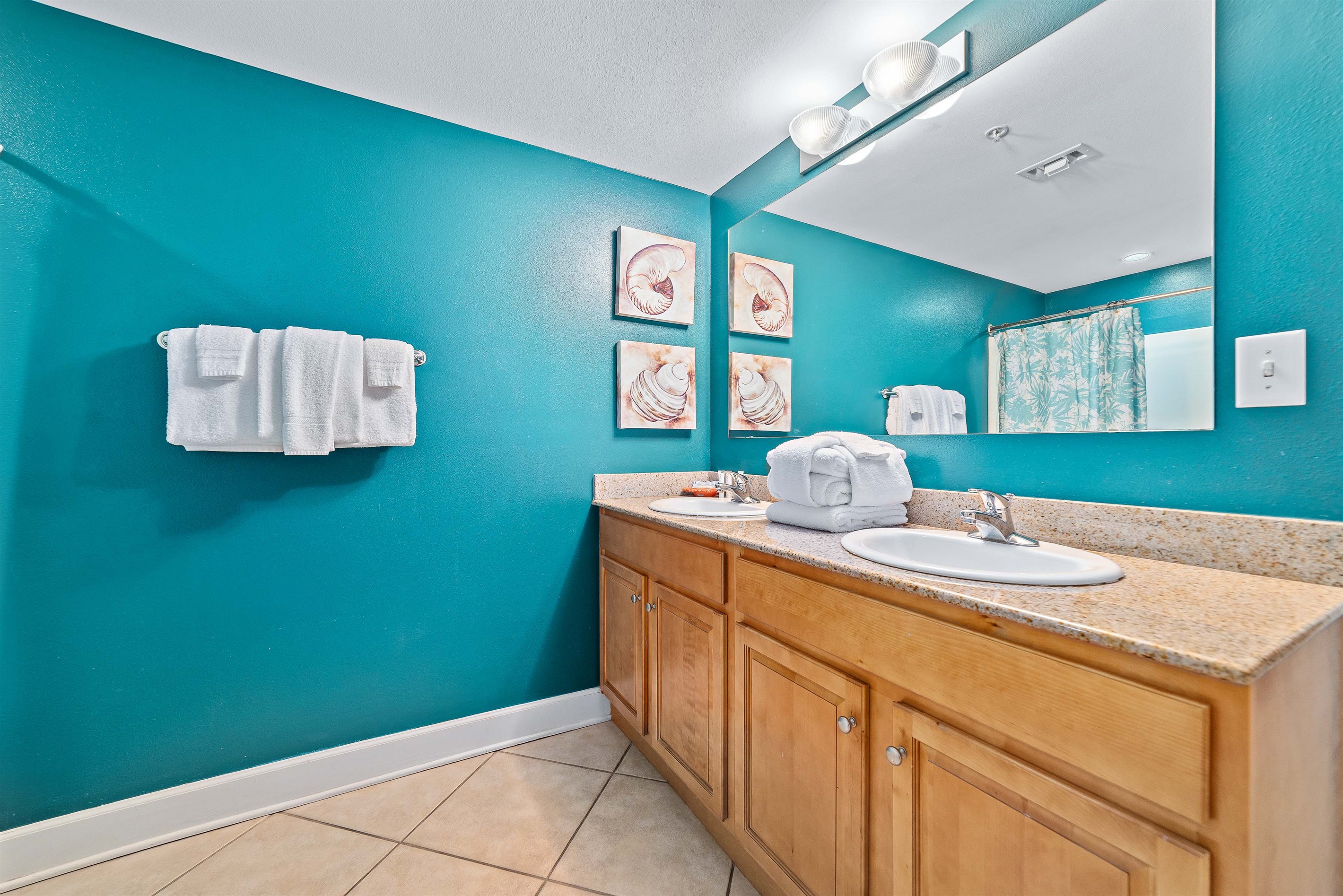 Modern and clean design. With ample lighting, a shower/tub combo, and fresh coastal decor, this guest bathroom provides all the necessary comforts for a seamless stay.