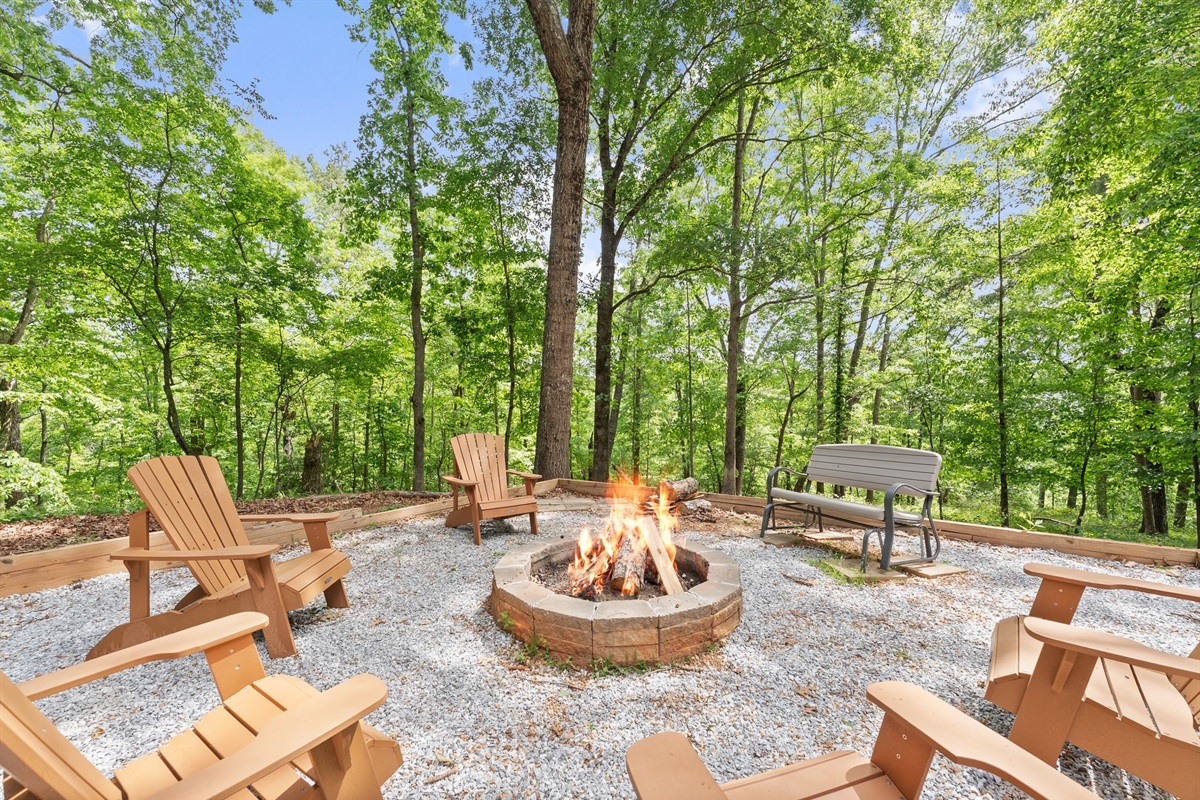 Rustic outdoor firepit surrounded by peaceful forest views &mdash; the perfect daytime spot for coffee, conversation, and fresh mountain air.