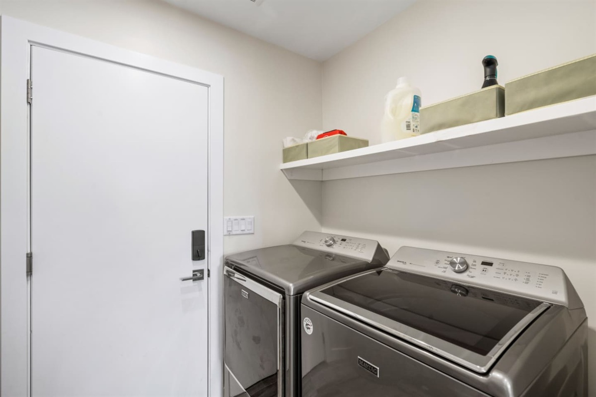 Laundry room with full-size washer and dryer, shelf storage, and supplies for added convenience during your stay.