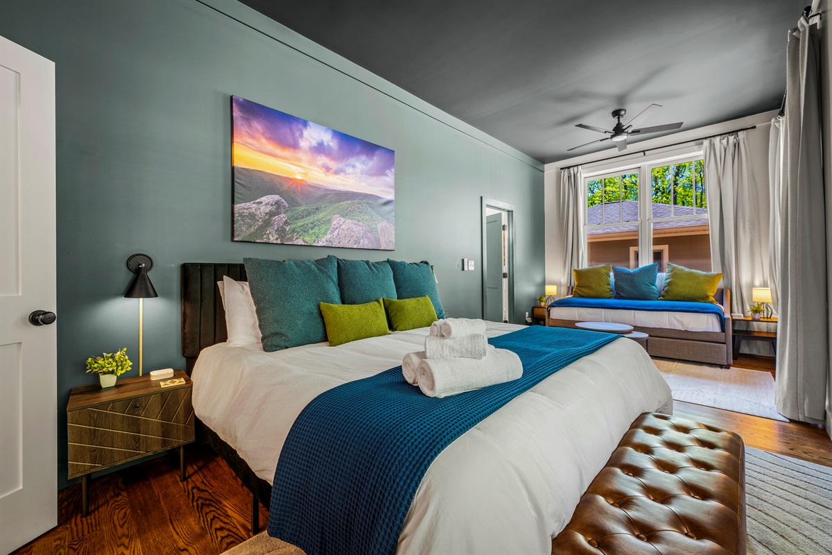 This serene main-level master features a king-size bed topped with local Asheville photography and a cozy twin daybed with trundle—ideal for parents with kids or anyone needing extra room to stretch out.