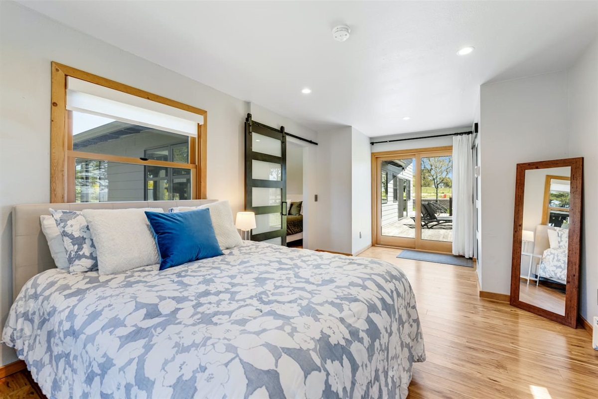 Relaxation meets outdoor charm. Queen-size bed with direct deck access. 