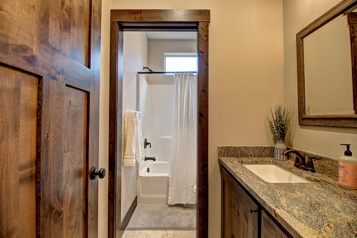Fresh towels, warm lighting, and a granite vanity make this bathroom feel like a little retreat of its own.