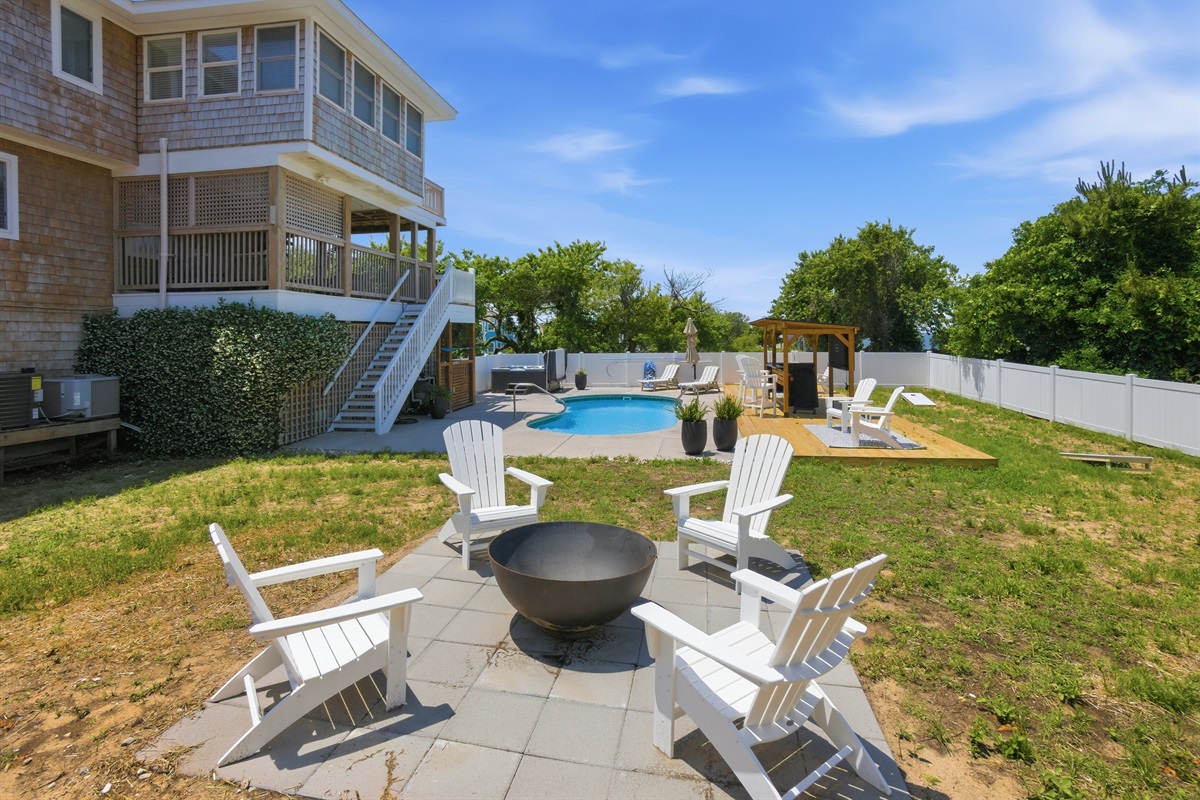 Backyard gathering space with fire pit seating and pool views