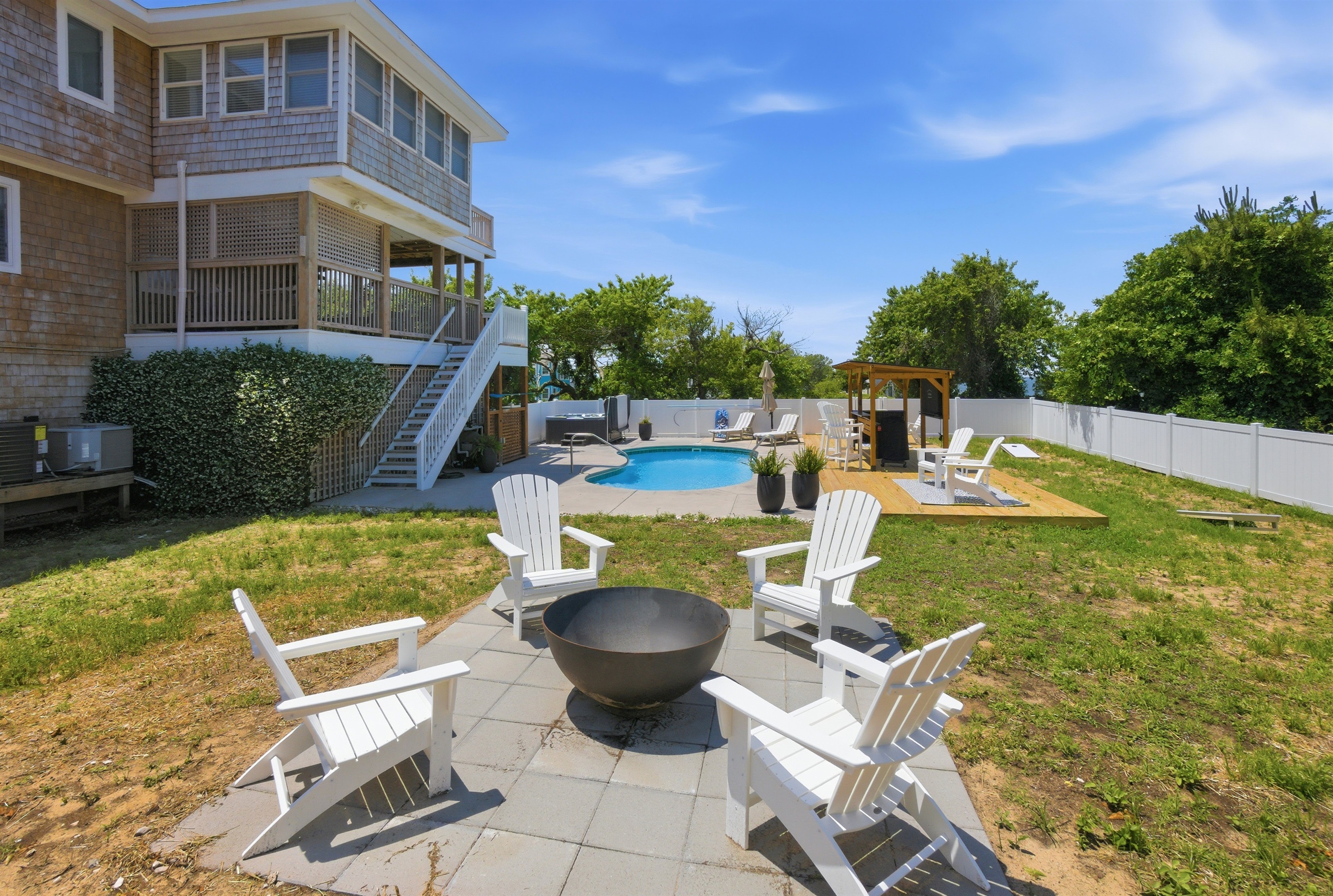 Backyard gathering space with fire pit seating and pool views