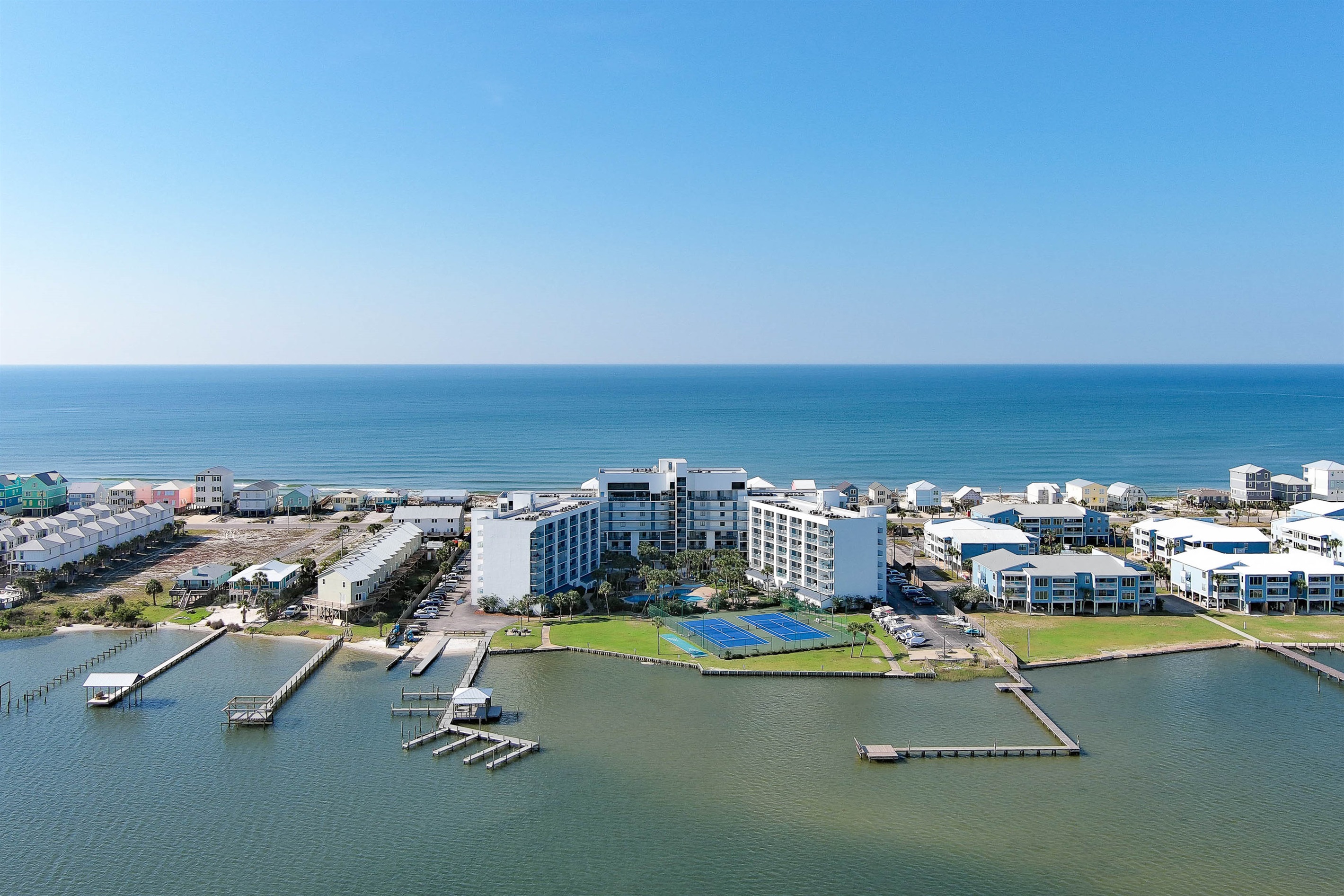 Stunning aerial view of Gulf Shores Surf and Racquet Club showcasing its unique position between the Gulf of Mexico and Little Lagoon.